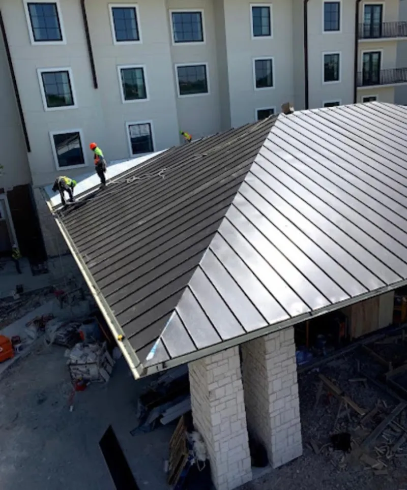 Crew installing standing seam metal roof panels on a commercial project in Kanab